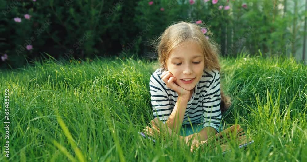 Hand near face. Happy girl 8 aged in the grass. Dolly shot Hand near face. Happy girl 8 aged in the grass. Dolly shot