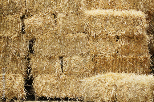 Fotografija bale of hay stacking inside shed of farm