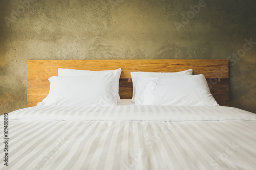 close up Bedroom Suite interior with white pillows and wall concrete background