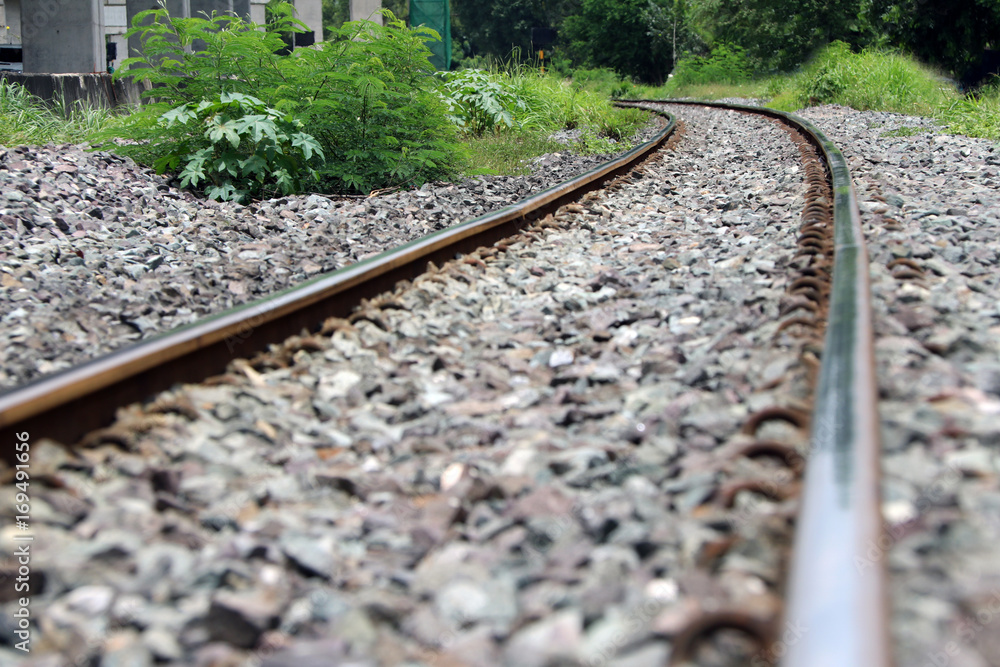 Obraz premium Railroad tracks and rocks in Thailand, metal railway of train and background green tree.