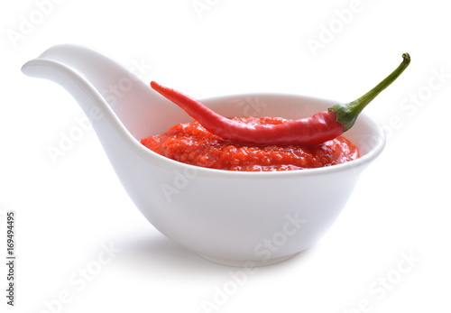 Red chili sauce in the sauce boat. With pepper. photo