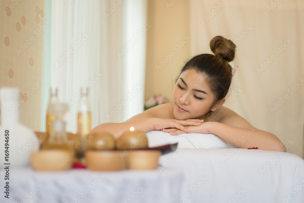 Beautiful smiling woman with flowers resting in the spa before massage. Beautiful smiling woman with flowers resting in the spa before massage.