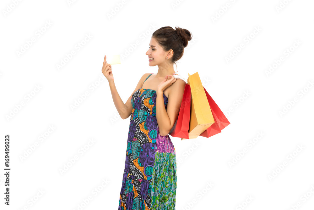 Young beautiful woman with credit card in hand and holding shopping bags over white background Young beautiful woman with credit card in hand and holding shopping bags over white background