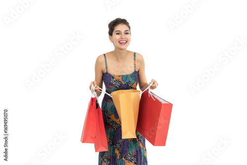 Young beautiful woman holding shopping bags over white background