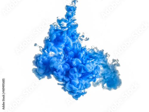 Ink swirl in water isolated on white background. The paint in the water. Soft dissemination a droplets of blue ink in water close-up. Abstract background. Explosion of splashes yellow acrylic ink.
