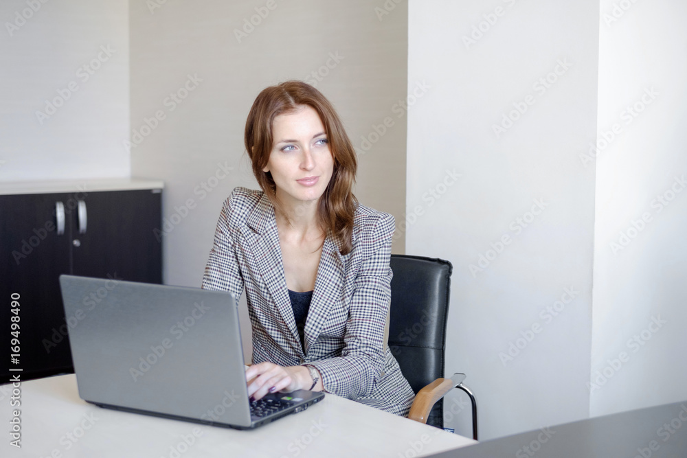 Portrait of a young business woman using laptop at office Portrait of a young business woman using laptop at office