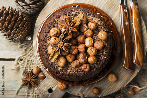 Homemade chocolate crazy cake with chocolate chips, nuts hazelnuts, cinnamon and spices for a cozy autumn tea party. Top View. photo