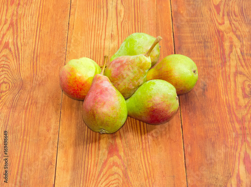 Red and green European pears on a wooden surface
