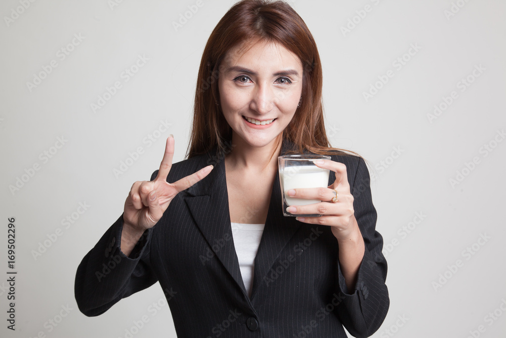 Healthy Asian woman drinking a glass of milk show victory sign. Healthy Asian woman drinking a glass of milk show victory sign.