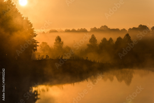Sunrise over foggy lake at autumn © marcin jucha