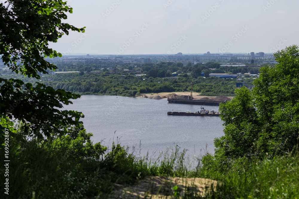 View of the Oka river and the lower part of the city. Nature landscape, city, and house, barges and boats.
