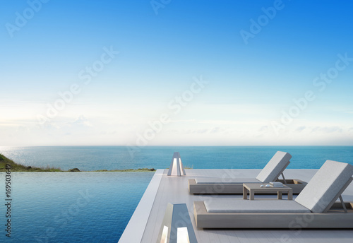Sea view swimming pool and terrace in modern luxury beach house with blue sky background  Lounge chairs on wooden deck at vacation home or hotel - 3d illustration of tourist resort