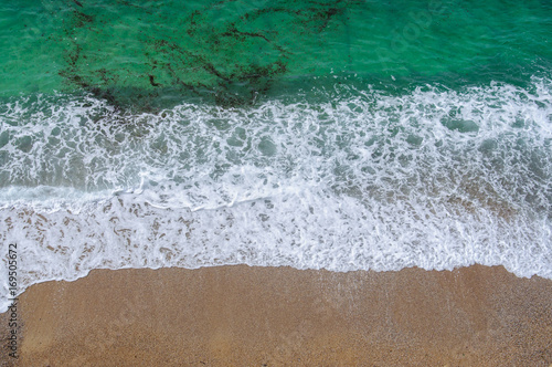 The aerial view of the sea water and the beach in summer