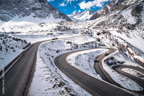 Mountain Winter Road Landscape. Snow Sunset Background Landscape. Mountains Rocks, Peak, Cliff. Isolated Forest. Winter Wallpaper. Christmas Blue Nature Background. Amazing Winter Mountains Sunrise