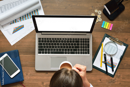 A person works at a computer with graphs, drawings and drinks coffee. Business, calculations, statistics and economics