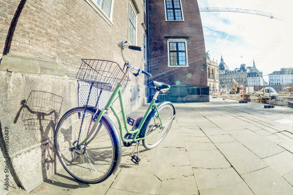 Green retro parked bicycle on a street in Copenhagen