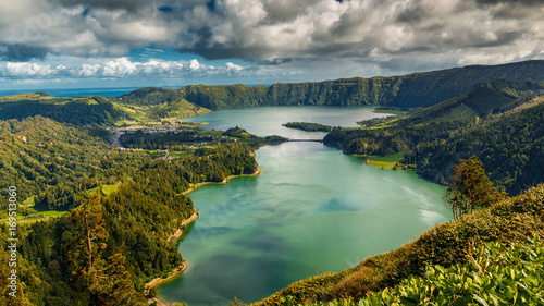 Establishing shot of the Lagoa das Sete Cidades lake taken from Vista do Rei in the island of Sao Miguel, The Azores, Portugal. The Azores are a hidden gem holiday destination in Europe. photo