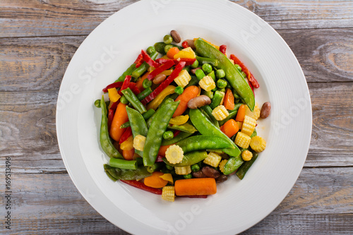 Stir fry vegetables on white plate. Copy space. Flat lay style
