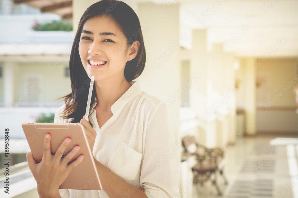 Asian women businessmen use tablet to contact work and business. Asian women businessmen use tablet to contact work and business.