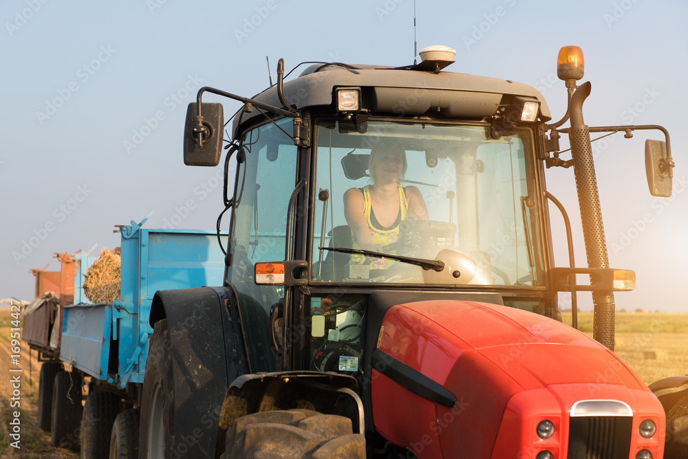 Beautiful, young farmer girl is driving tractor Beautiful, young farmer girl is driving tractor