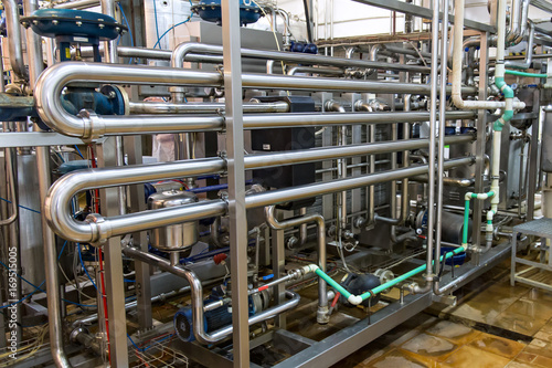 Industrial dairy production. View on the steel pipelines on the milk factory.