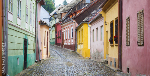Fototapeta Naklejka Na Ścianę i Meble -  old street with colorful houses in Sighisoara medieval city, Romania