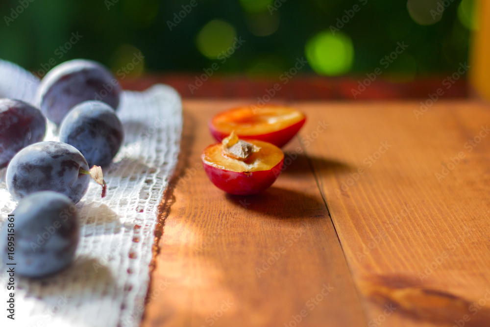 Plums ripe fresh on the wood texture background