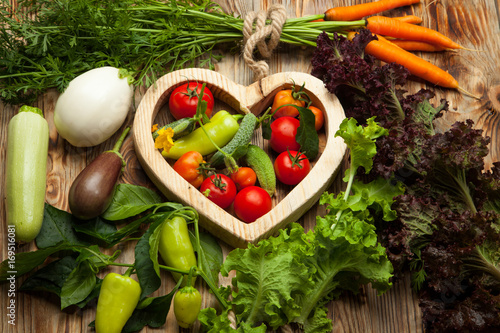 Vegetables in the heart on a rustic wooden background