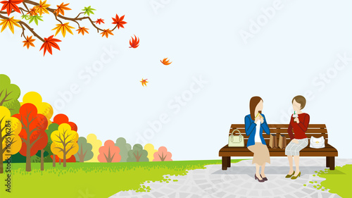 Two women lunch in the autumn park