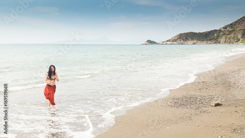 Young woman walking alone in barefoot at the shore © Mirko Macari