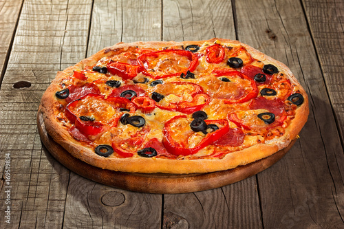 Delicious pizza served on wooden plate 