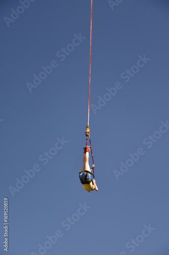 Young girl bungee jumper hanging on a cord