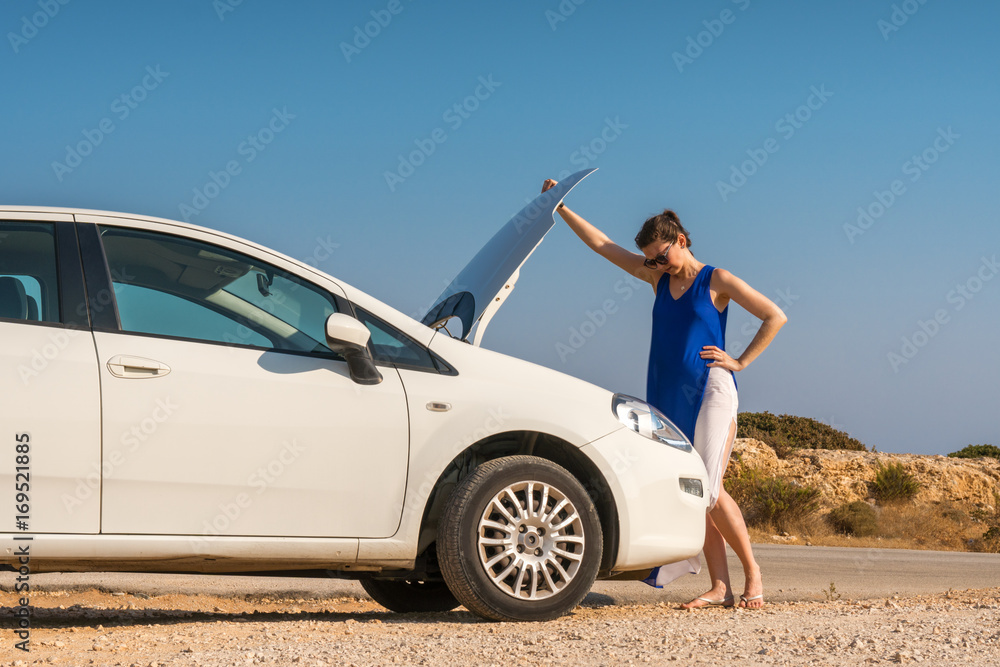 girl in the blue dress standing next to not working a white car