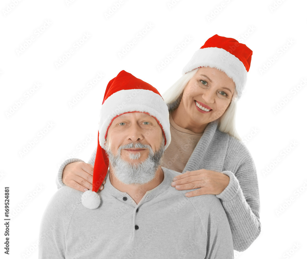 Happy senior couple with Christmas hats on white background Happy senior couple with Christmas hats on white background
