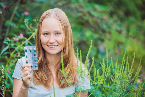 Young man holds in her hand allergy tablets because of an allergy to ragweed photo