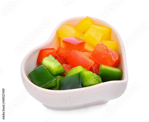 chpopped sweet bell pepper or capsicum in the white heart cup isolated on white background