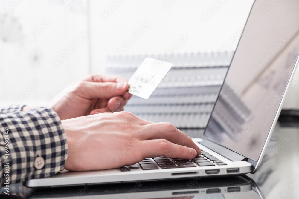 Hands with plastic card and laptop Hands with plastic card and laptop