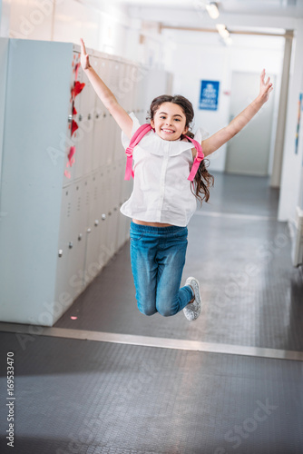 Fototapeta Naklejka Na Ścianę i Meble -  girl jumping in school corridor