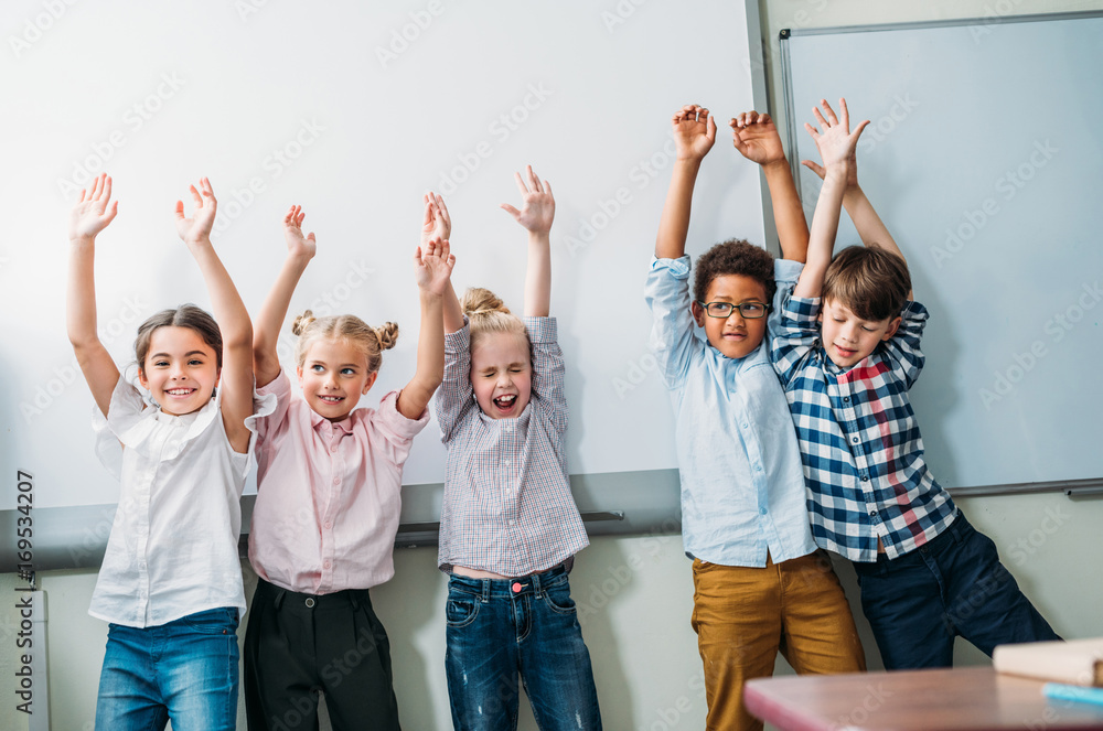 kids with raised hands next to whiteboard kids with raised hands next to whiteboard