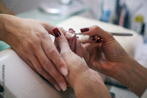 Close-up of female hands being manicured at a beauty salon.