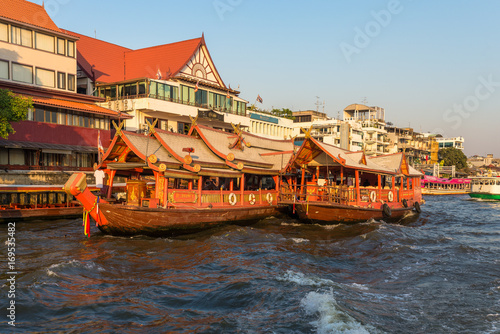 Ships at the pier for river cruise on a rice barge on the Chao Phraya river in Bangkok. Traditional rice barge, built for gastronomy on the river