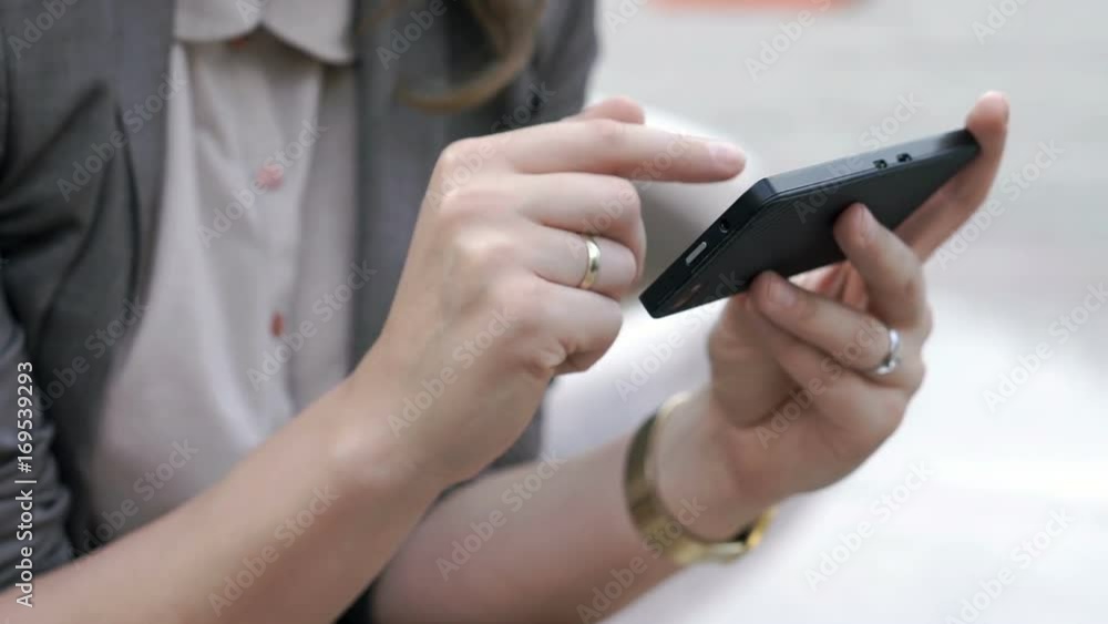 View of female's hands holding smartphone and browsing internet on it, steadycam shot
View of female's hands holding smartphone and browsing internet on it, steadycam shot