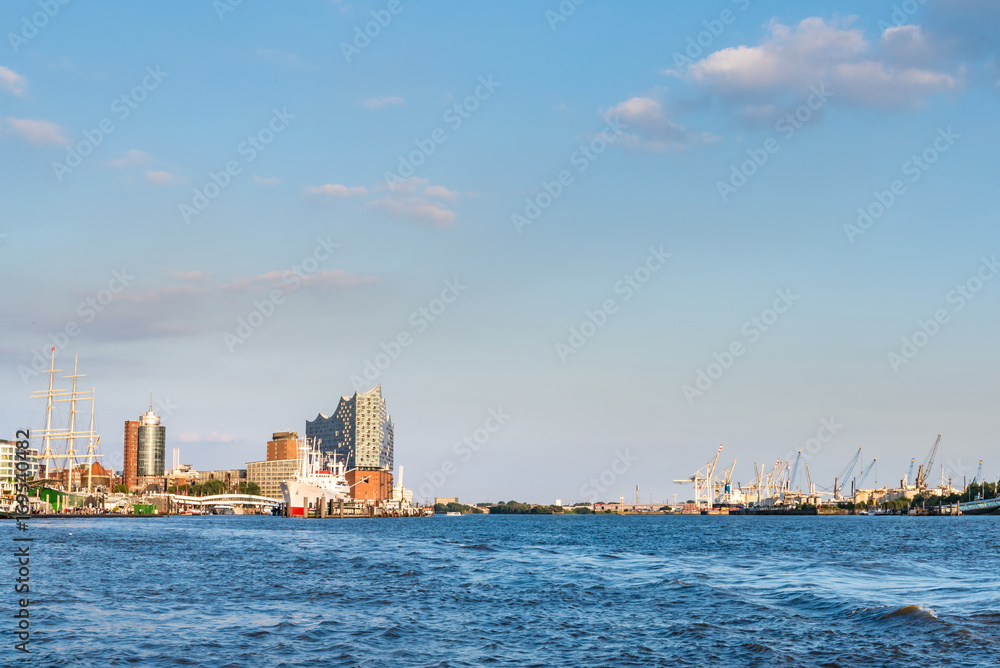 river Elbe with harbor, Sankt Pauli piers and Elbphilharmonie concert hall in Hamburg, Germany under clear blue sky