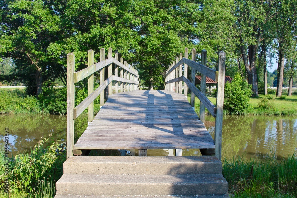 A view of the front of a wood bridge in the park.