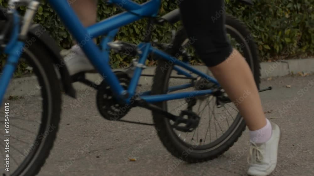 Woman in glasses starts on a bicycle in the park. Woman in glasses starts on a bicycle in the park.