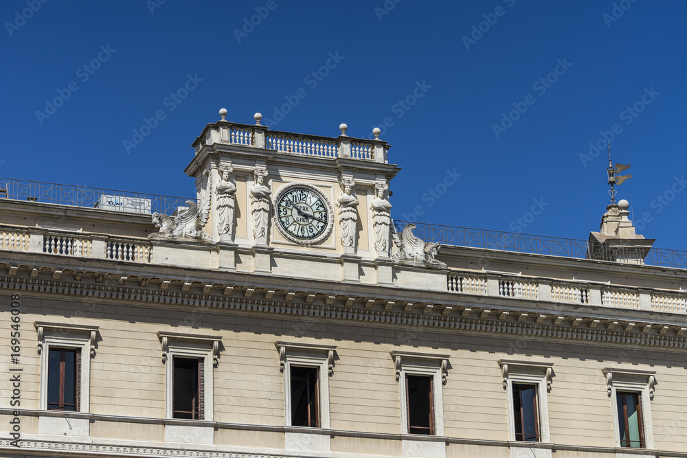 Antique clock on facade of an old classic building in Rome, Italy. Decoration with elegant architectural details