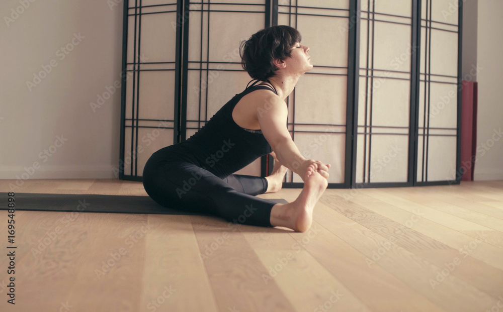 A young woman performing yoga-asanas in the hall. A young woman performing yoga-asanas in the hall.