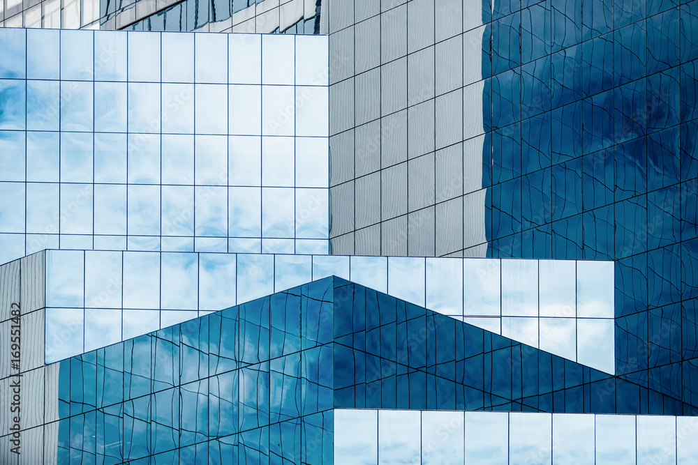 Blue sky and clouds reflecting in windows of modern office building - obrazy, fototapety, plakaty 