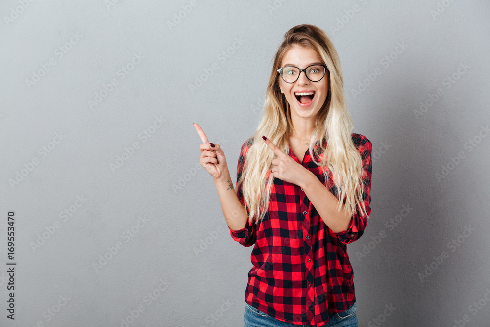 Young blonde woman pointing to copyspace Young blonde woman pointing to copyspace