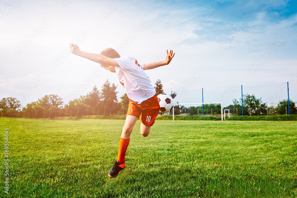 Boy playing with football ball on playing field. Boy playing with football ball on playing field.